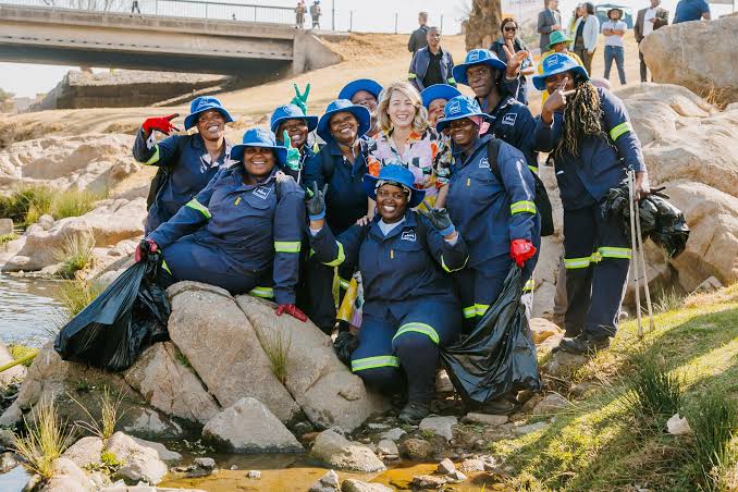 The Alexandra Water Warriors, a local partner to the SUNCASA project, welcome Minister Joly to Alexandra, showing her the work done to clean up the banks of the Jukskei River. Photo: Jenna Echakowitz/SUNCASA